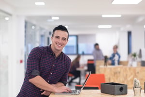 employee standing next to his laptop