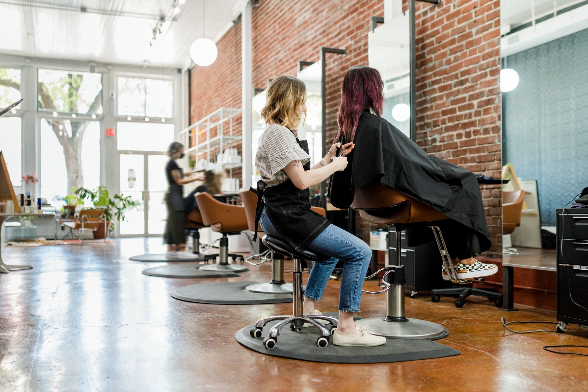hairstylist-trimming-hair-of-the-customer-in-a-bea-2023-11-27-04-53-52-utc